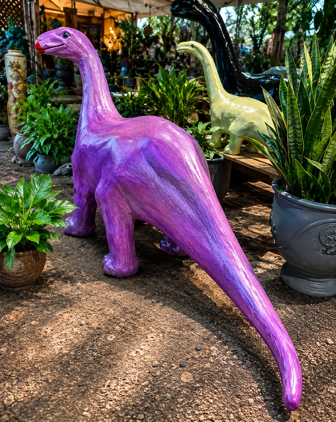 Medium dinosaur cast aluminum garden statue shown in a patio and garden lifestyle setting.