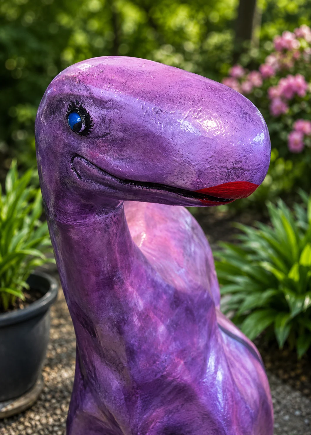 Medium dinosaur cast aluminum garden statue shown in a patio and garden lifestyle setting.