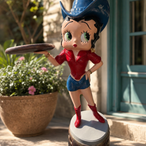 Sculpture Shops retro pin-up cowgirl cast aluminum statue displayed on a home patio